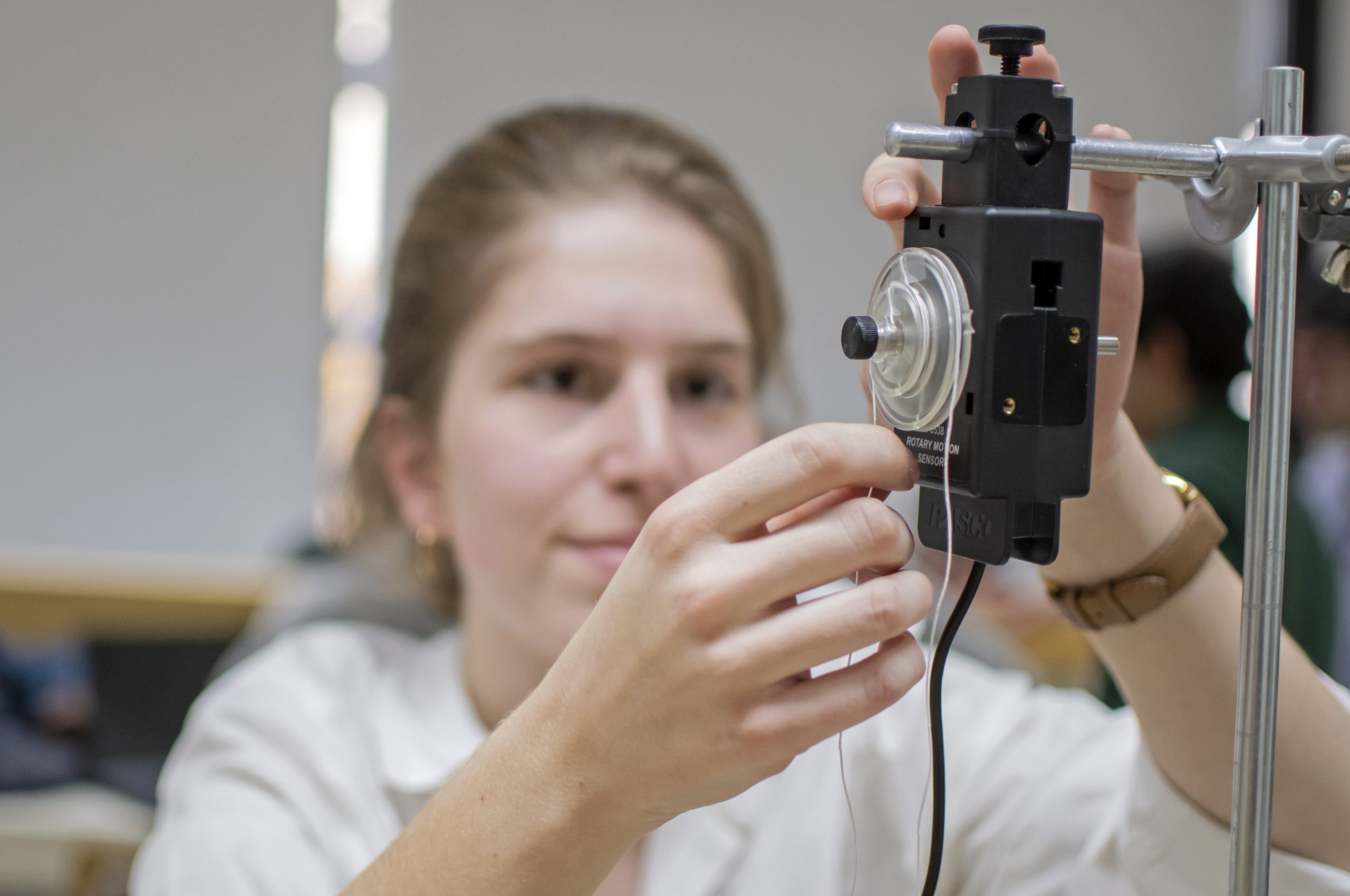 Estudiante manipula experimento en laboratorio docente