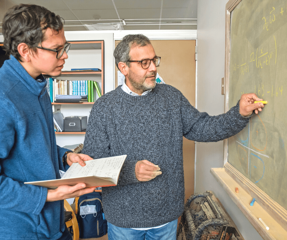 Profesor y estudiantes trabajando frente a pizarrón